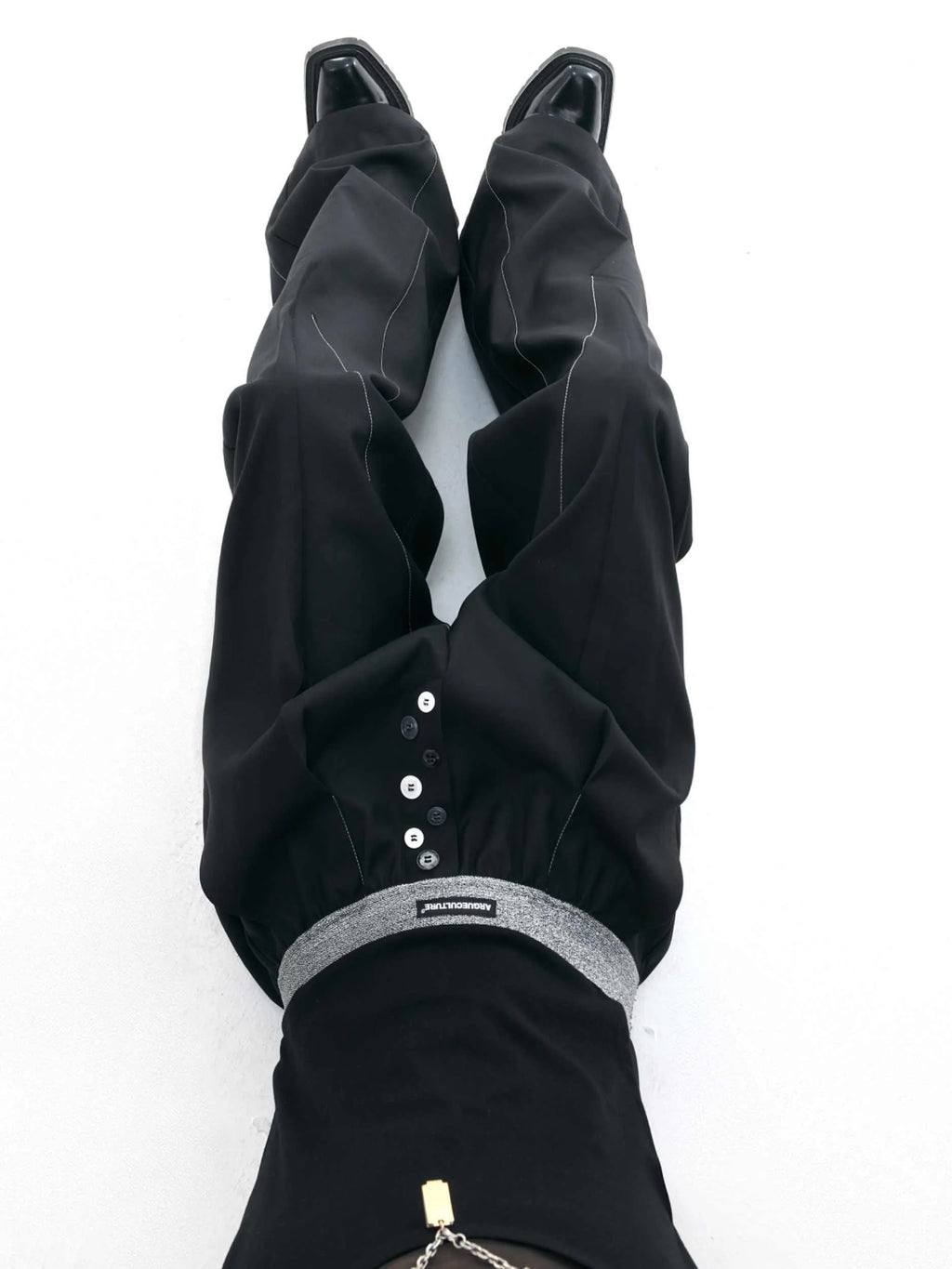 Black high-waisted straight-leg casual trousers featuring a button-open line design detail on the leg.