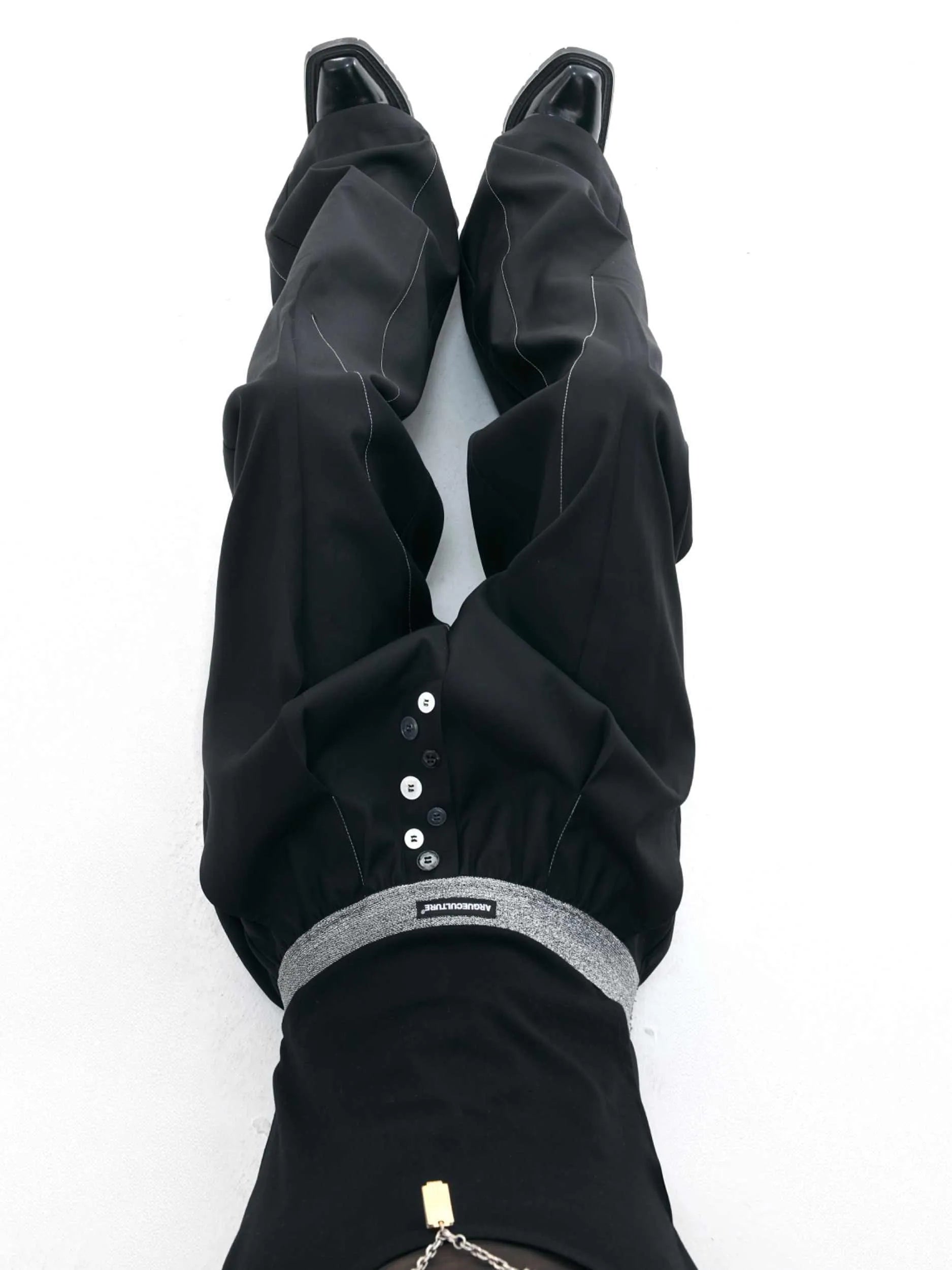 Black high-waisted straight-leg casual trousers featuring a button-open line design detail on the leg.
