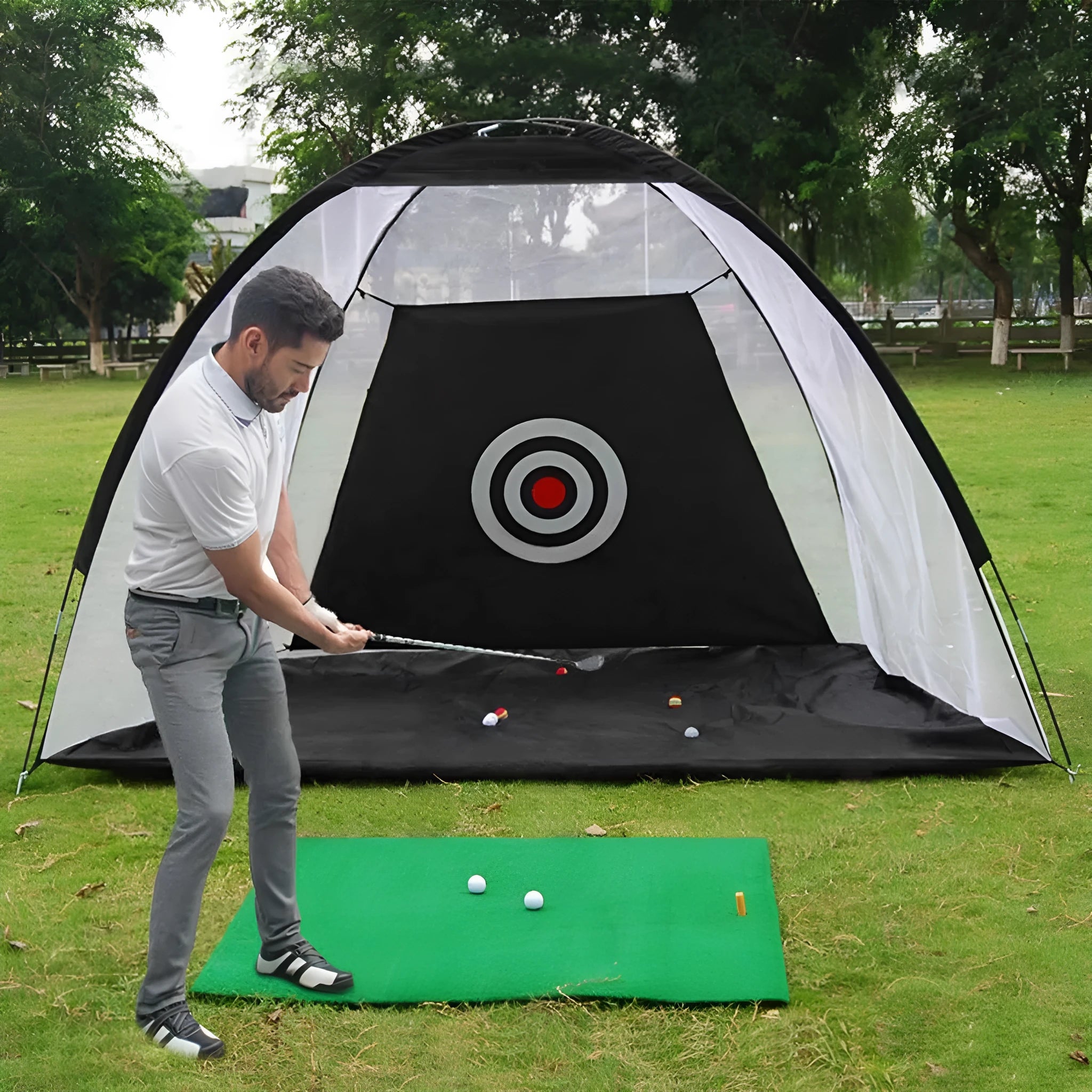 Black and green golf practice net tent set up on grass with fibreglass poles and target sheet