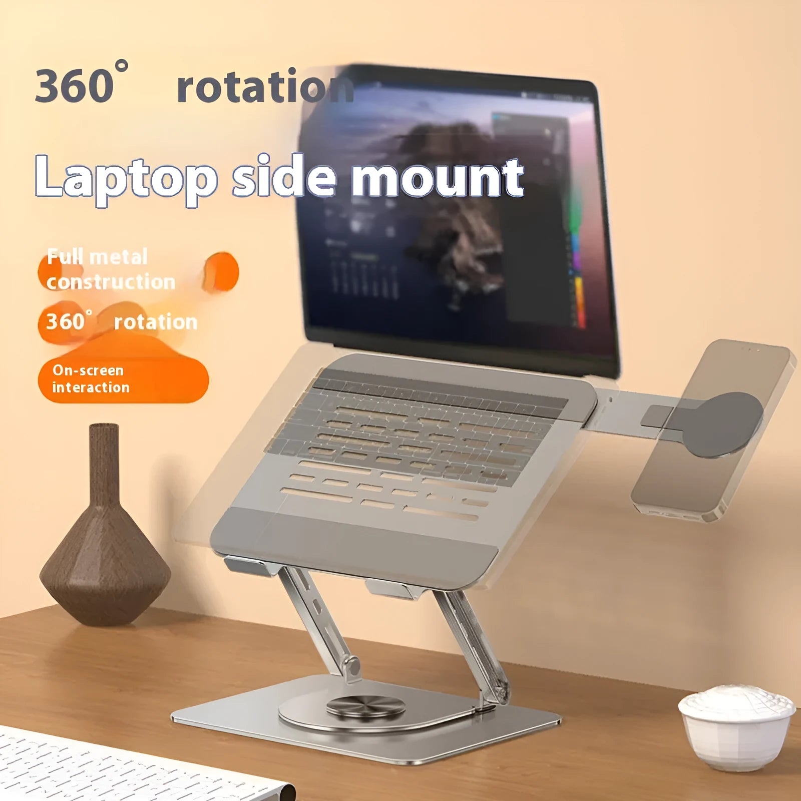 Silver carbon steel laptop stand with a rotating base and a side-mounted magnetic mobile phone holder.