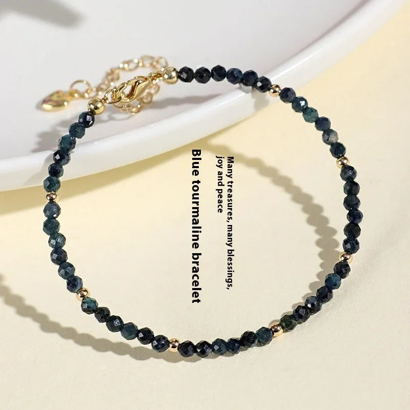 Blue tourmaline gemstone bracelet with 3mm beads and gold spacer details.