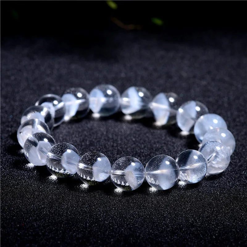 Women's white crystal pyramid bead ghost bracelet with a Ruyi charm on a white background.