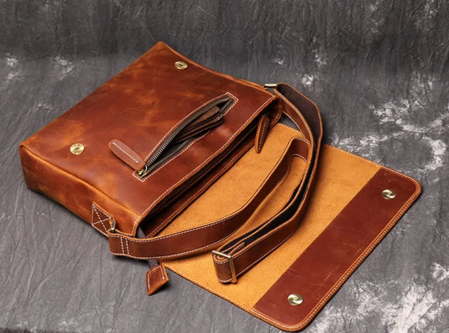 Men's vintage brown cowhide shoulder bag showing medium size and cross-body strap