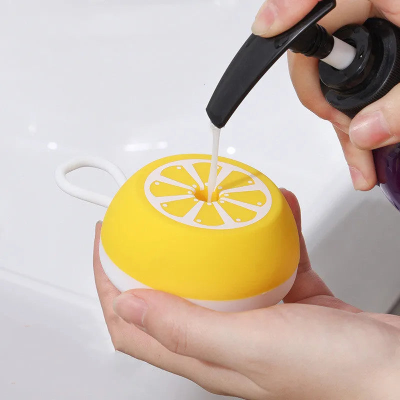 A yellow soft silicone pet bath brush with a 3D massage head on one side and a comb on the other, shown on a blue background.