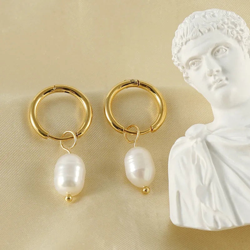 Gold geometric stainless steel earrings with a central white cultured pearl on a post.