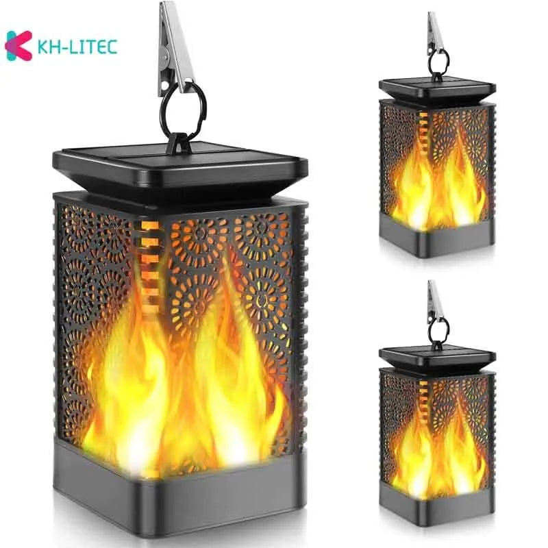 Set of four black solar-powered hanging lanterns with flickering flame LED light for outdoor garden decoration.