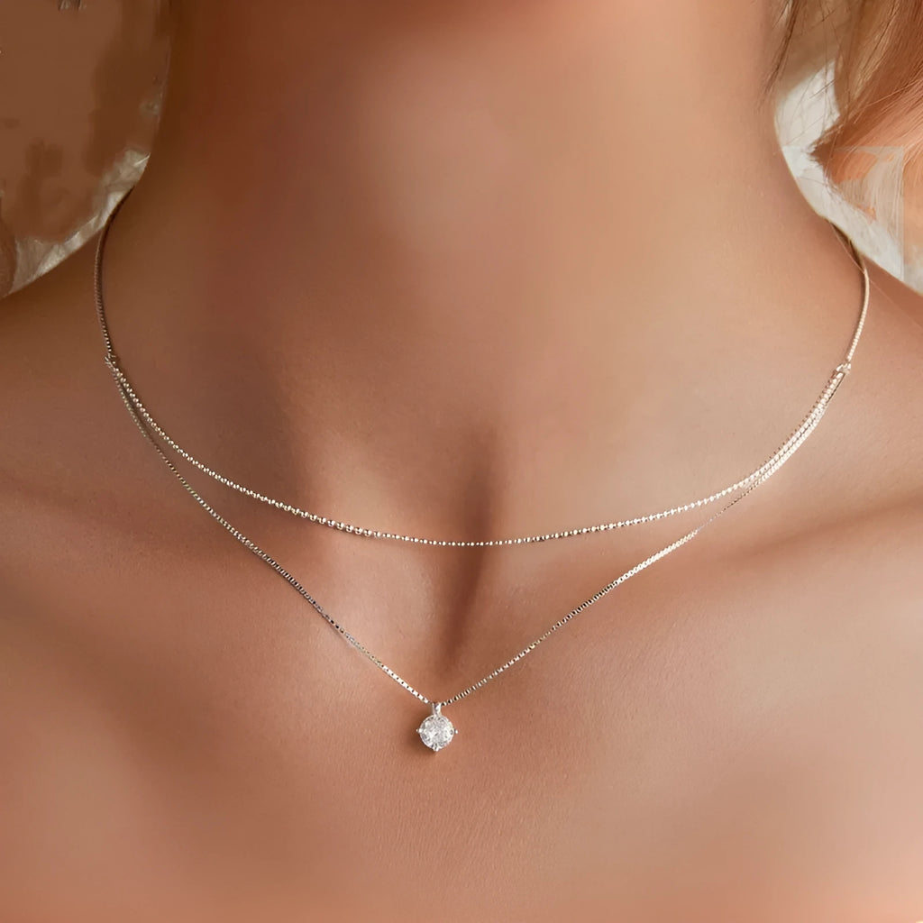 Close-up of a women's double-layer pearl chain necklace in S925 sterling silver with a shining pendant.