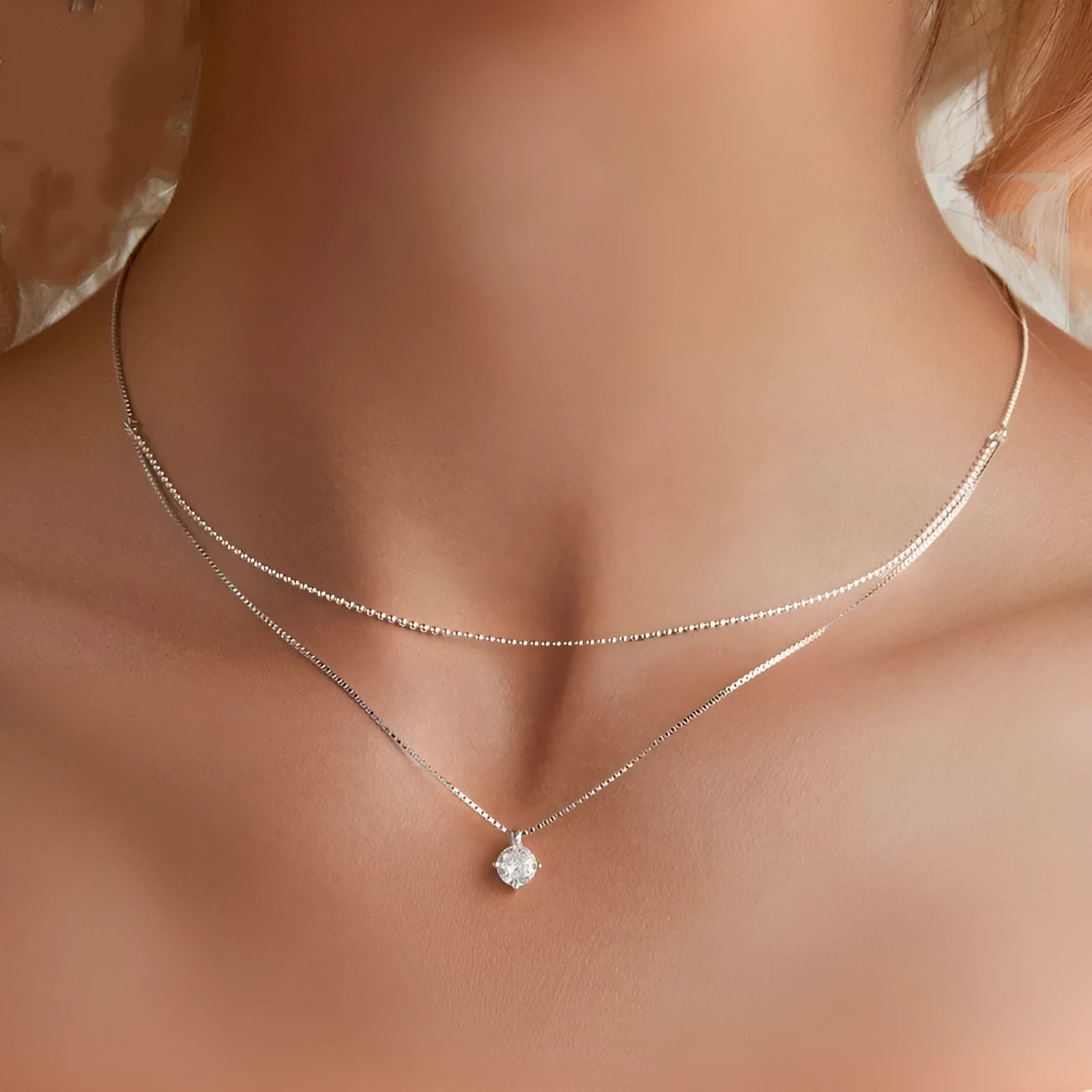 Close-up of a women's double-layer pearl chain necklace in S925 sterling silver with a shining pendant.