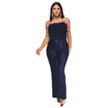 A woman wearing a black sleeveless backless jumpsuit with flared legs and sequin details.