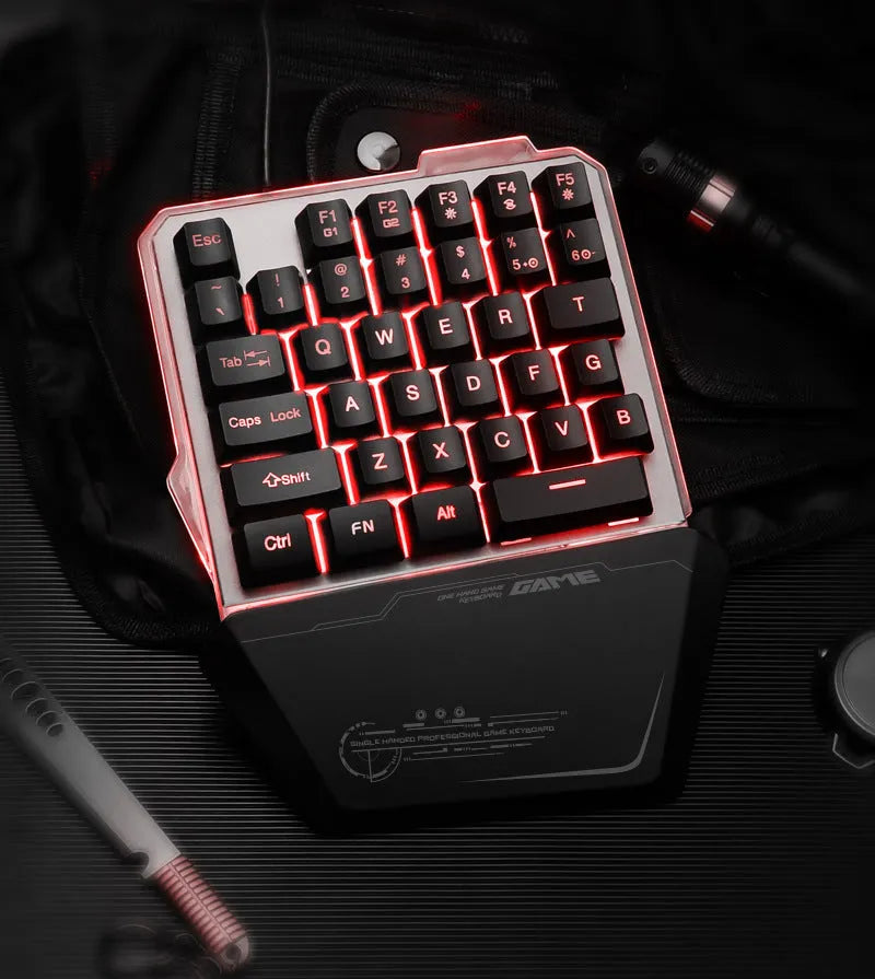 Black one-handed mechanical gaming keyboard with RGB backlit keys on a desk.