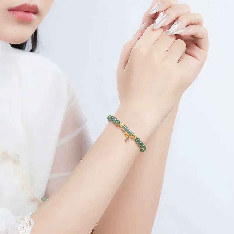 S925 sterling silver bracelet for women with a blue water round bead and cargo jade charm.