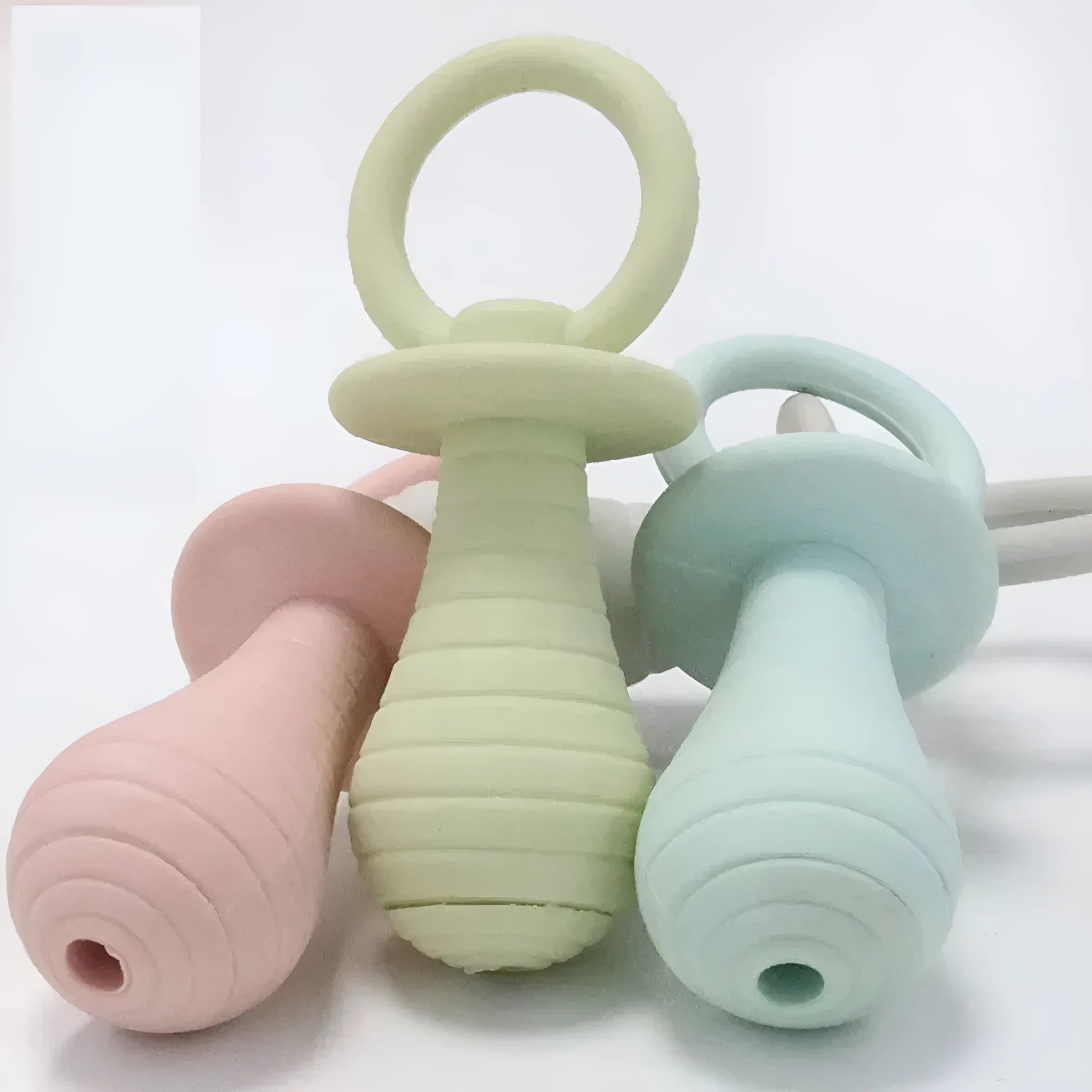 Set of four coloured TPR pet pacifier chew toys with squeakers for puppies and kittens.