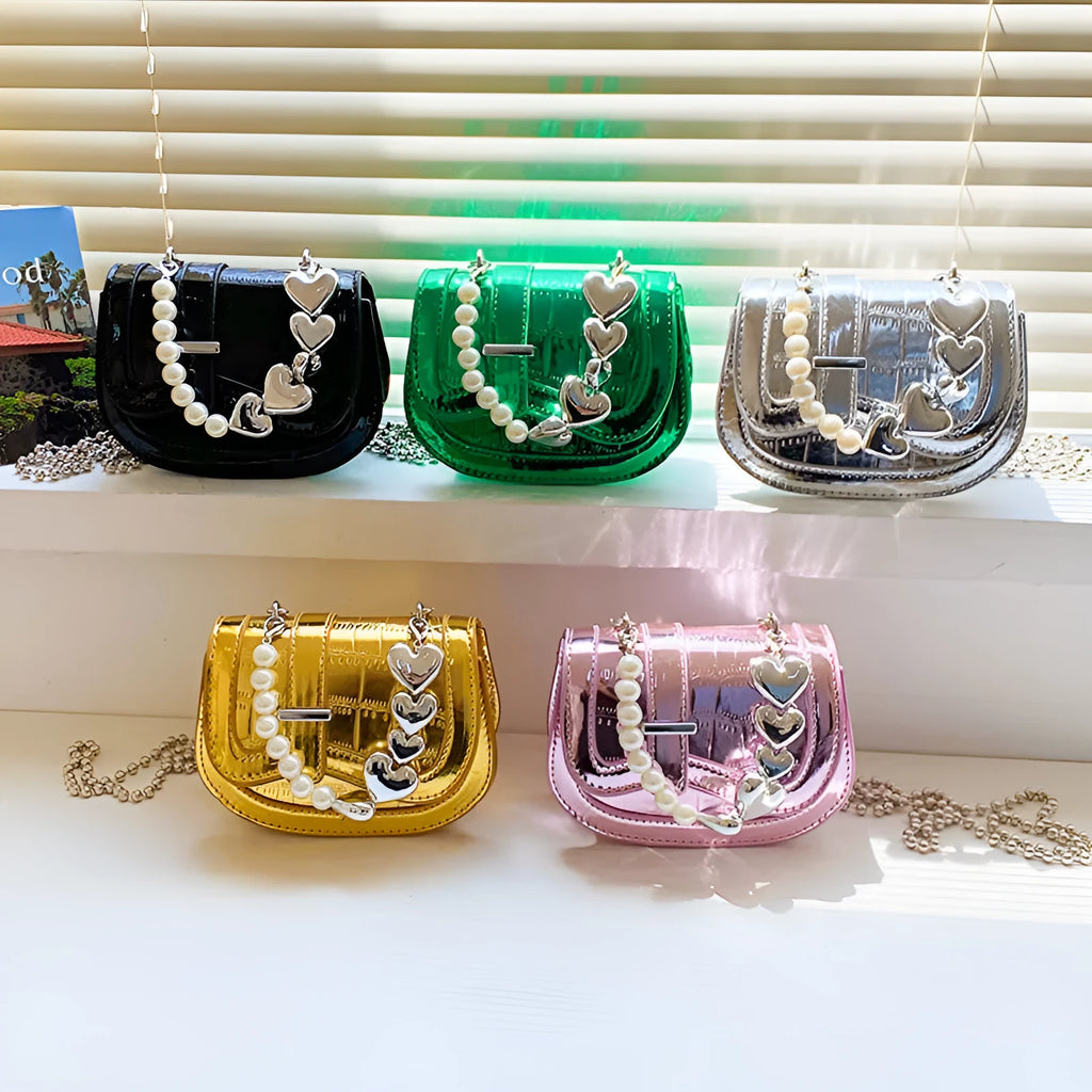 Laser pearl finish mini tote saddle crossbody bag in a choice of colours, shown with a single strap and structured square shape.