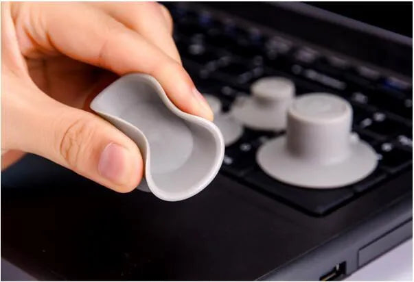 Grey durable plastic laptop cooling pads, two large and two small, on a table.