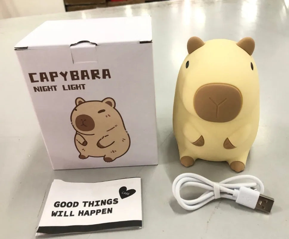 Small grey capybara-shaped silicone night lamp on a table.