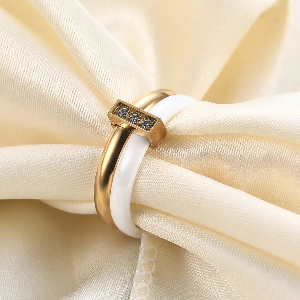 Glossy ceramic women's ring with inlaid zirconium design in geometric shape, shown in gold white finish.