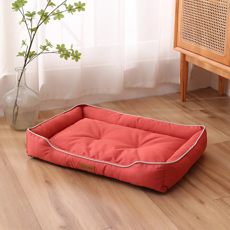 Gray luxury dog sofa bed with raised edges on a wooden floor, showing waterproof Oxford cloth and plush cushion.