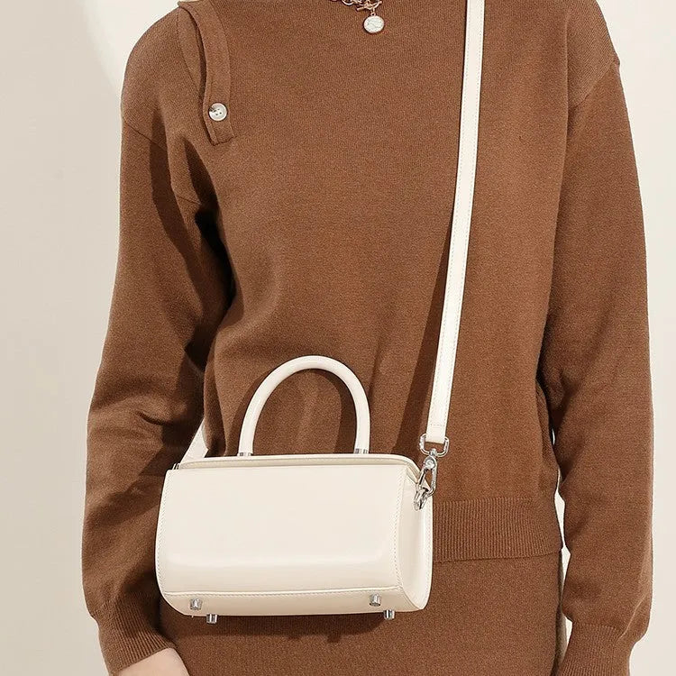 Women's black cowhide leather one-shoulder crossbody bag with clamshell opening, shown closed.