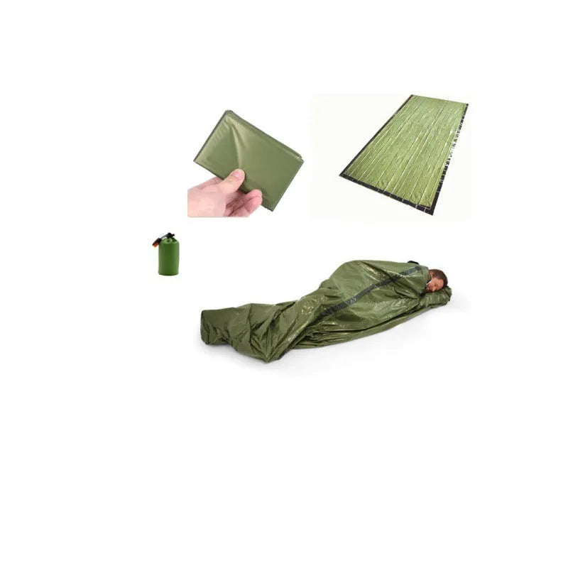 Orange aluminium foil emergency sleeping bag with drawstring bag and whistle on ground