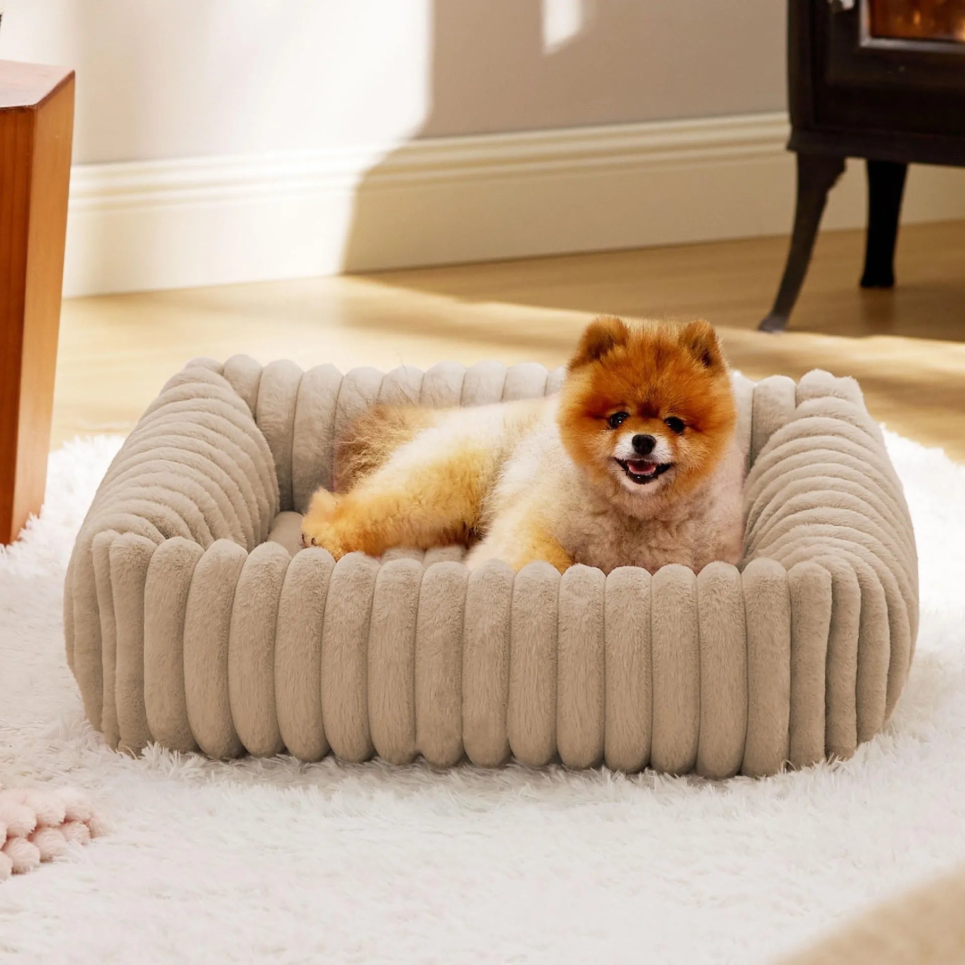 Grey pet bed with raised cushioned sides for a cat or dog.