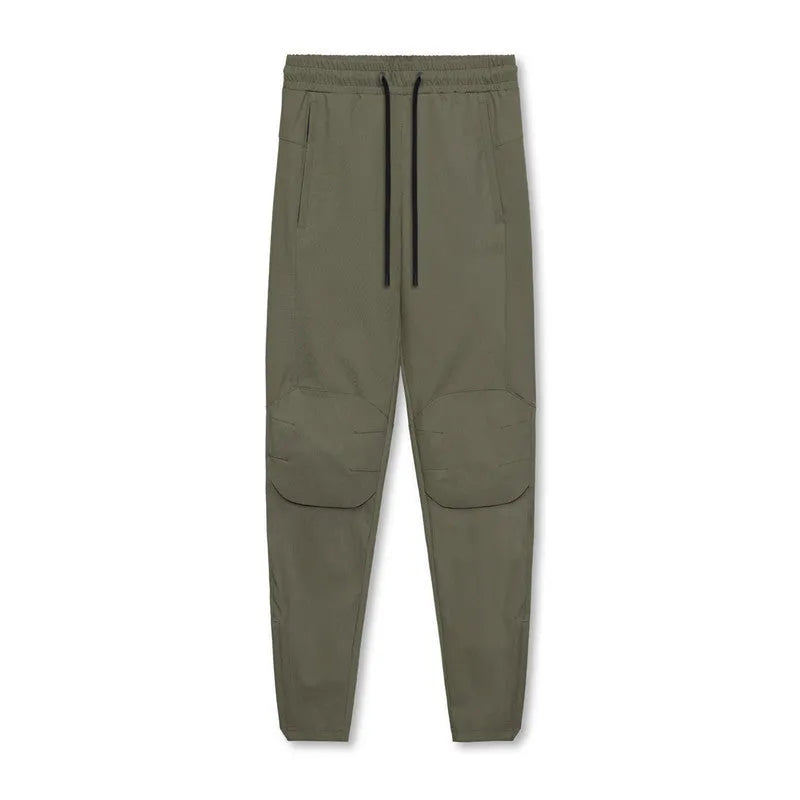 Men's loose grey running pants with ankle ties, laid flat to show mid-waist and full-length design.
