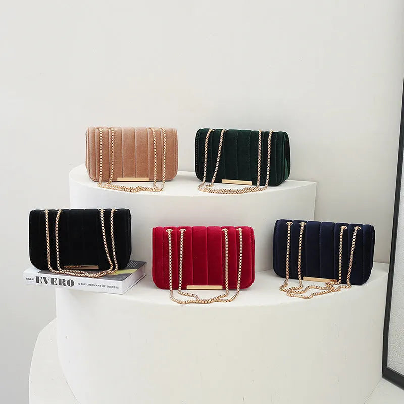 One shoulder velvet chain crossbody bag in solid colour, small square shape with gold chain strap, on white background.