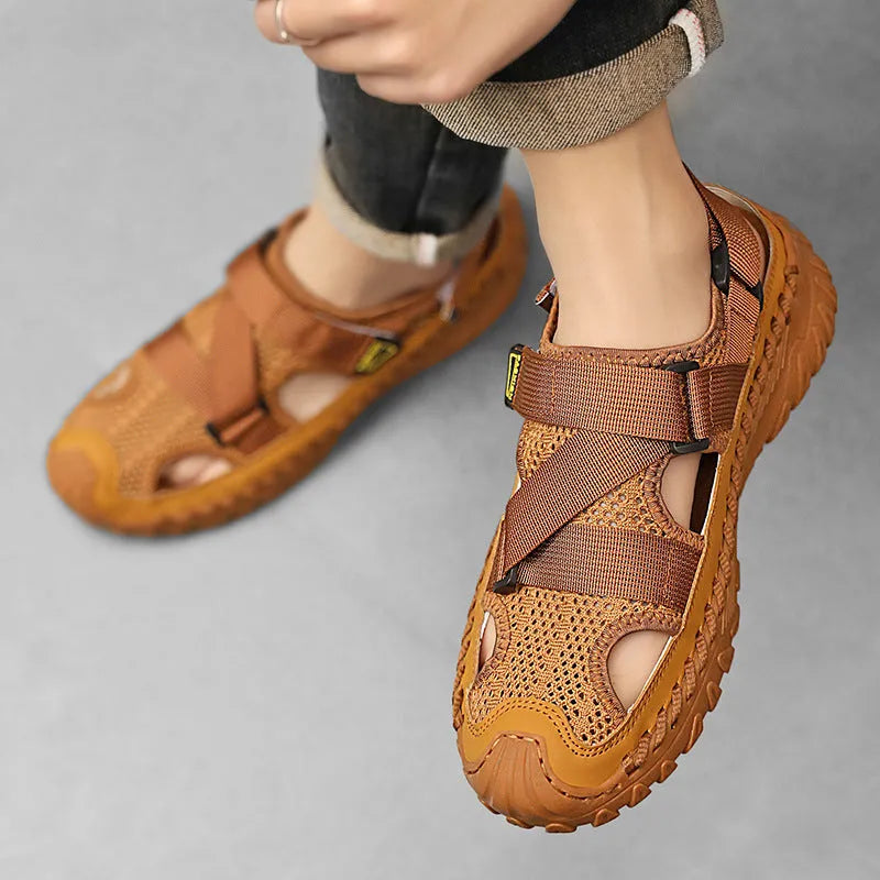 Men's grey casual sandals with a mesh lining, genuine leather upper, and an elastic band toe holder on a rubber sole.