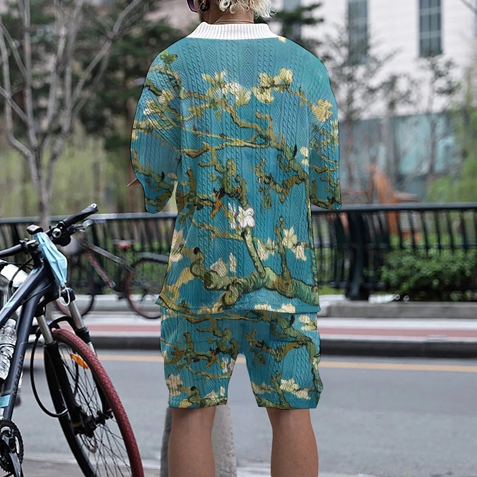 Peacock blue men's knitted casual suit with matching T-shirt top and shorts laid flat.