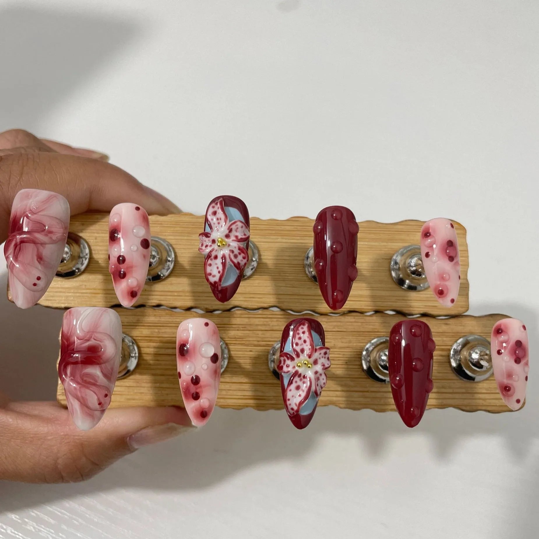 Almond-coloured hand-painted artificial nails with 3D carved rose and butterfly designs, shown in short and almond shapes.