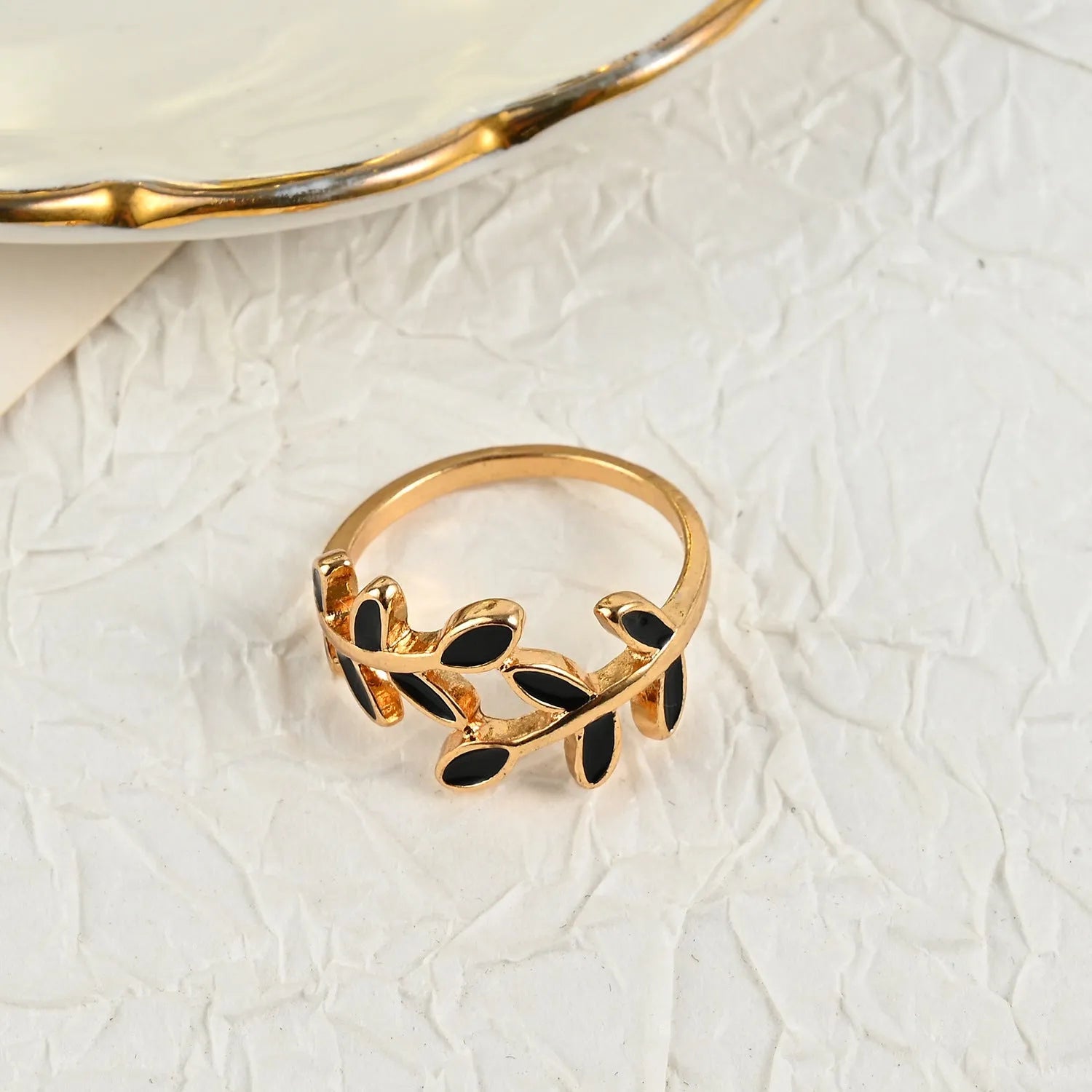 Gold geometric leaf design acrylic ring for women on a white background.