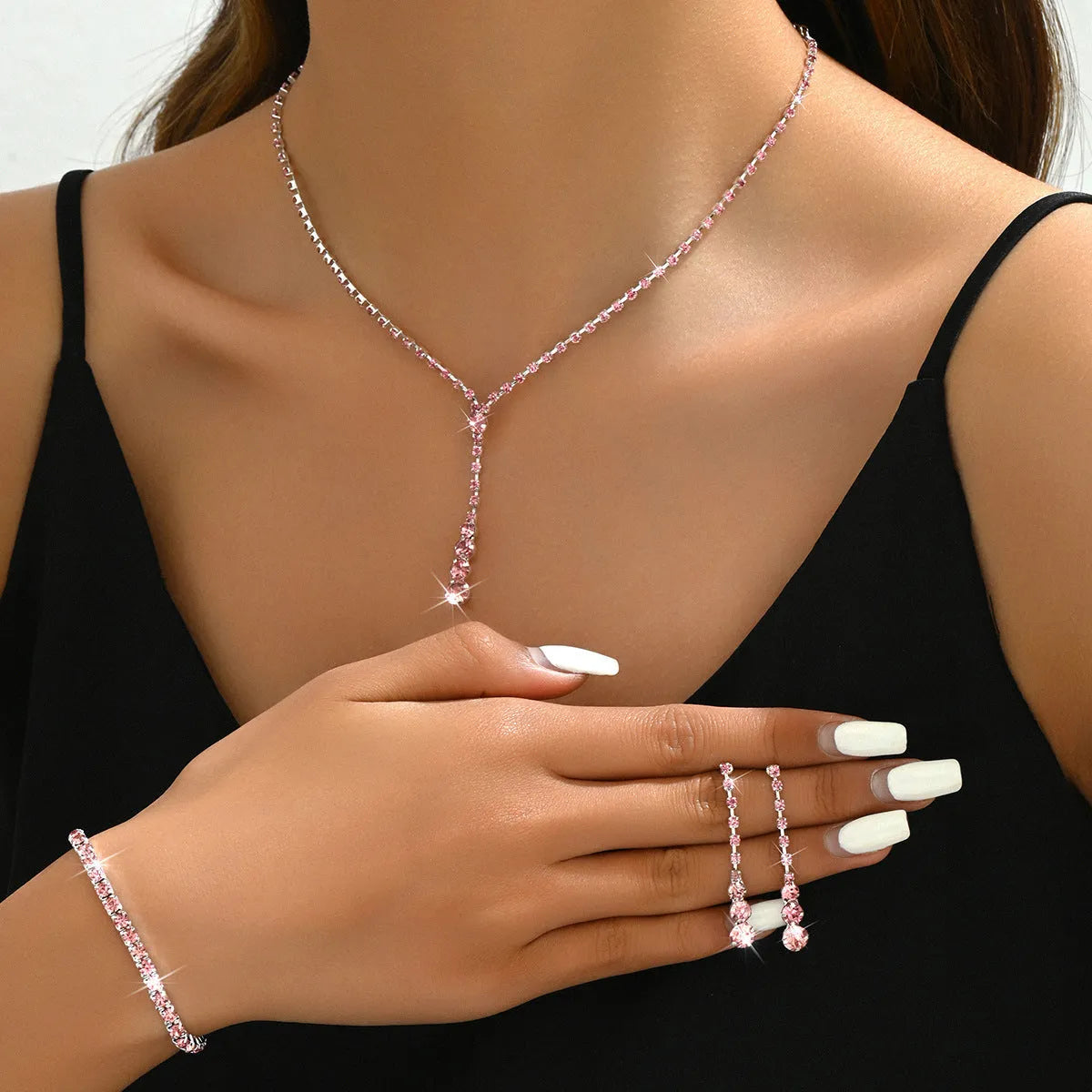 Women's rhinestone jewellery set with elastic bracelet, snake bone chain necklace, and earrings in rose gold finish.