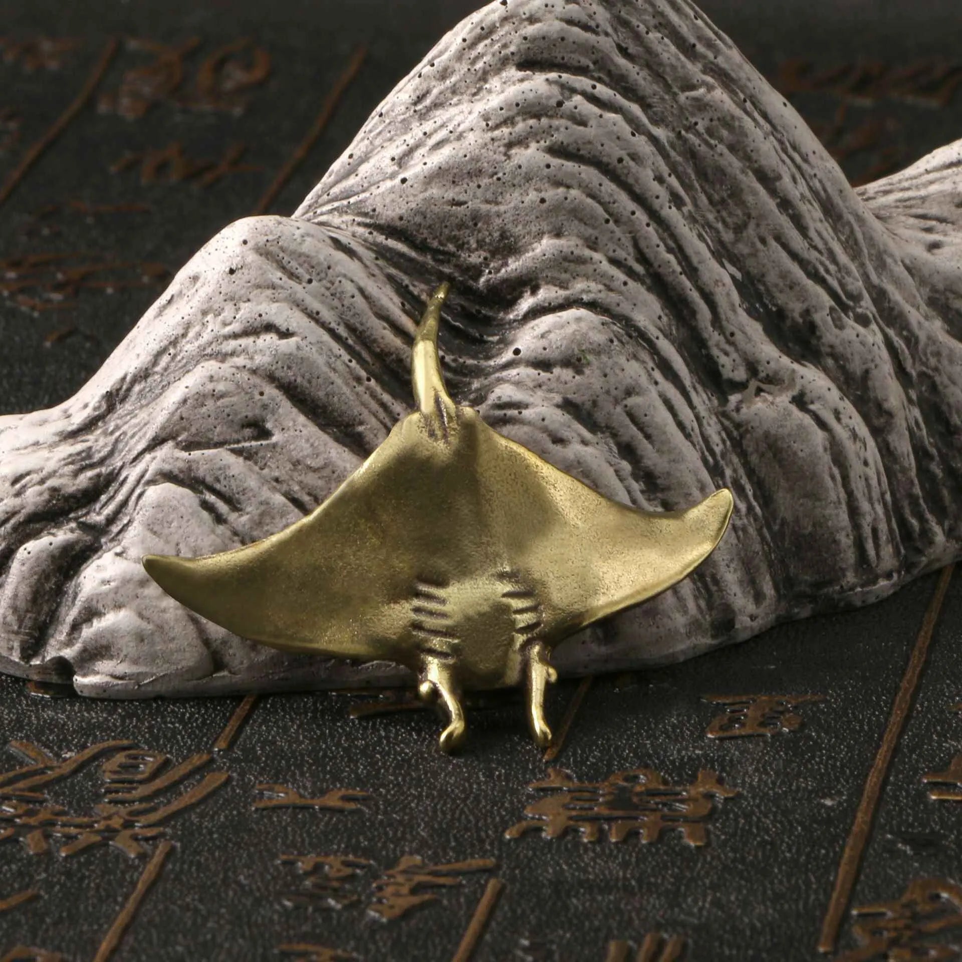 Brass devil fish ornament figurine on a surface, showing metallic colour and intricate devil fish design