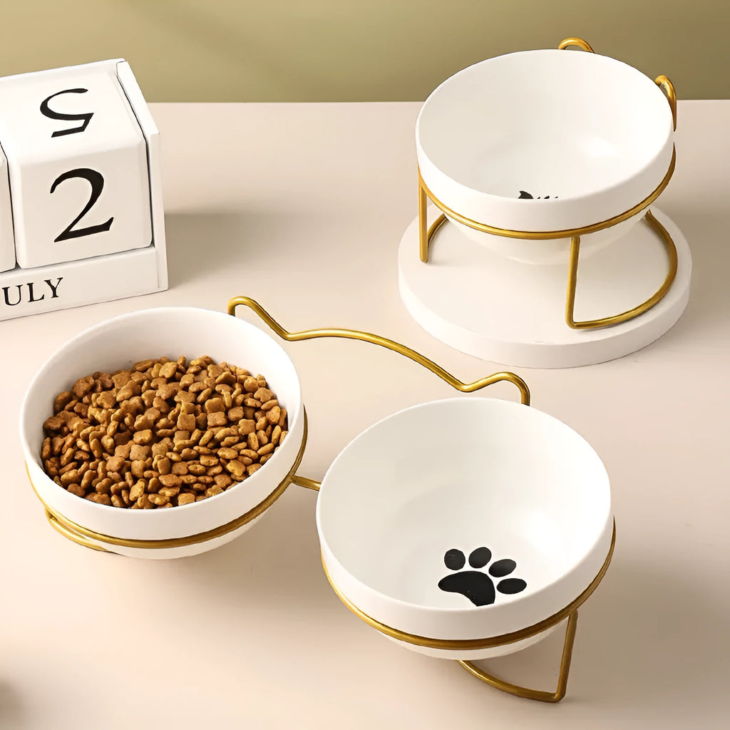 Pure white ceramic cat bowl with cat footprints design on a black iron frame stand with cat ears.