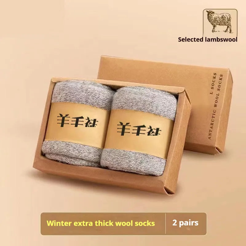 A pair of thick winter wool socks with a Merino midsole in a solid colour, shown next to its presentation box.
