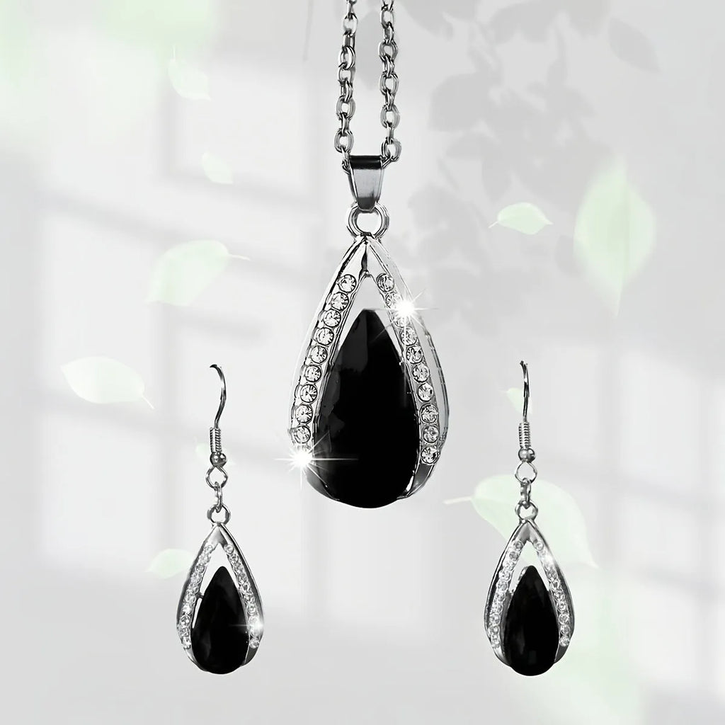 Black and red teardrop glass pendant necklace and matching earrings set on display.