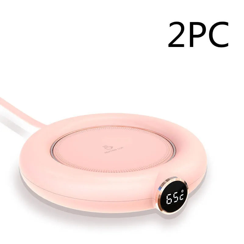 White USB cup warmer pad with LED display on a desk next to a mug.