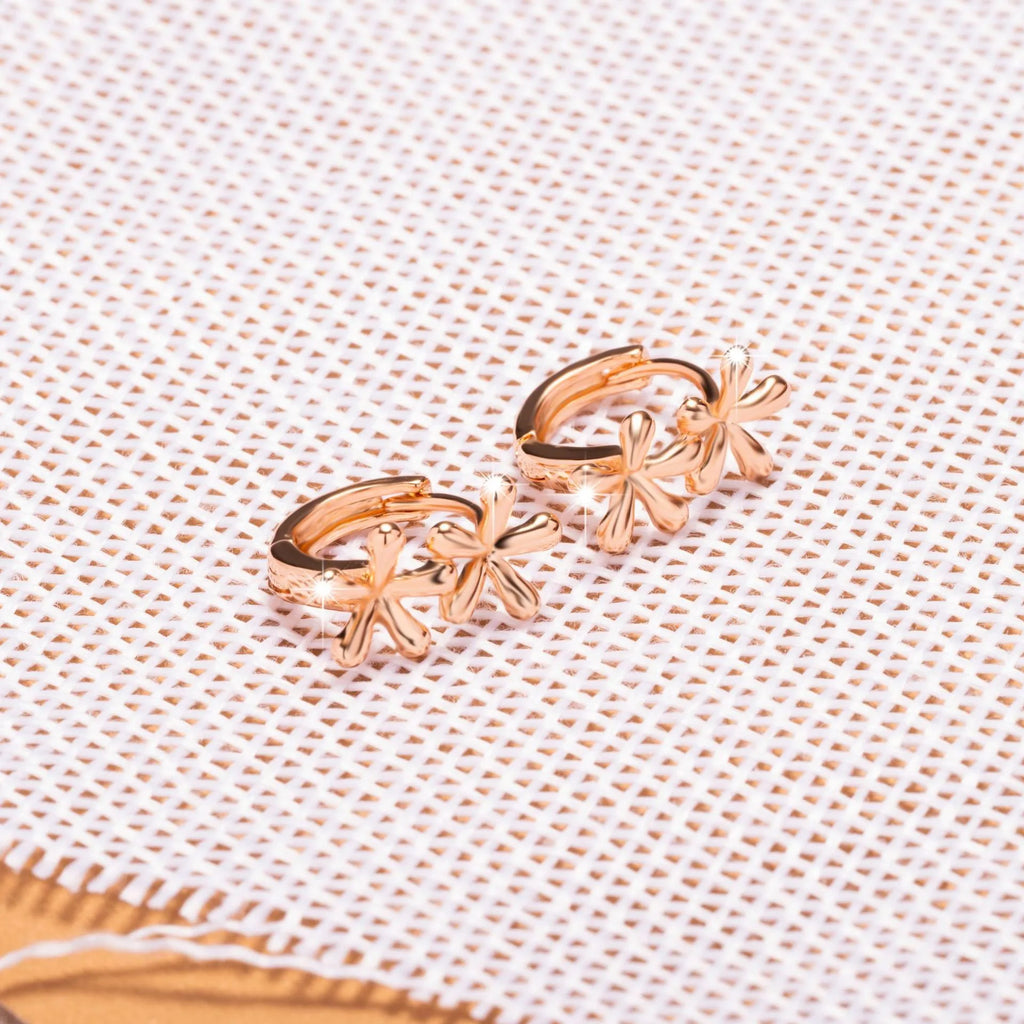 Rose gold circular earrings with a waterdrop flower design on a white background.