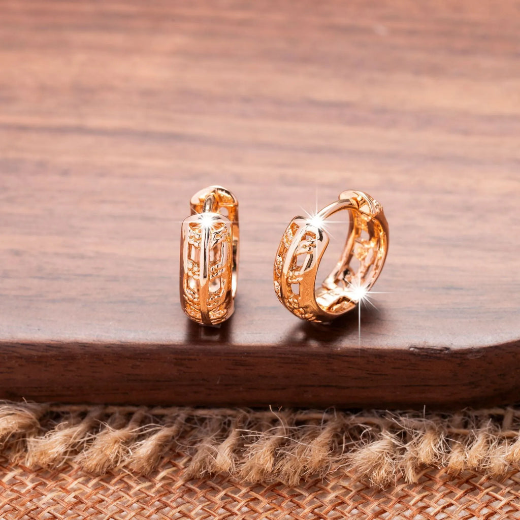 Rose gold coloured copper earrings with hollowed-out leaf and heart shapes.
