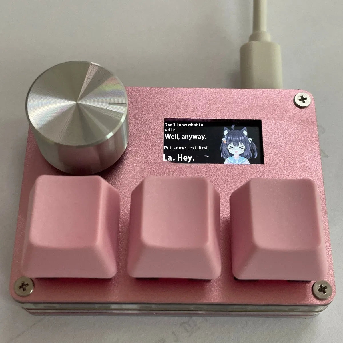 Magnetic axis gaming numeric keypad with colour screen, control knob, and RGB backlighting on a desk.