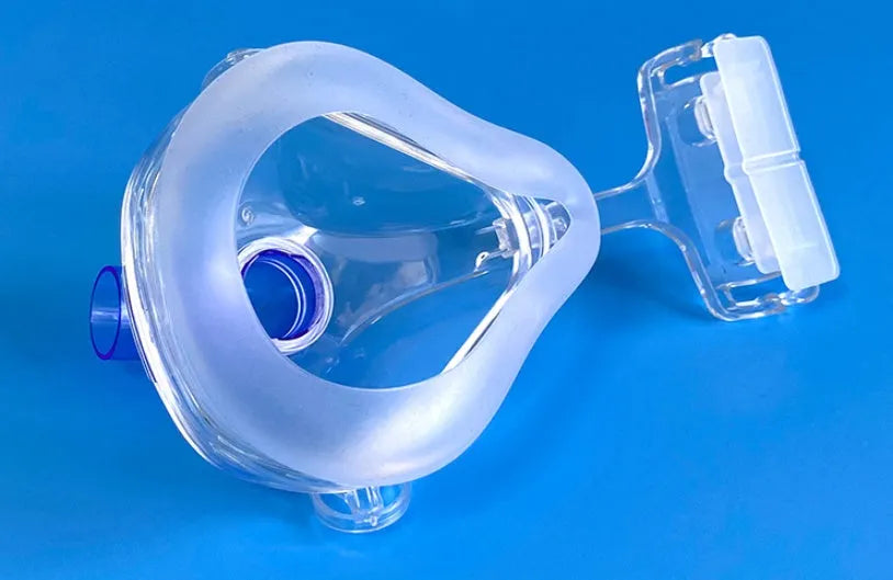 Transparent silicone CPAP breathing mask with headband and PC elbow adapters on a white background.