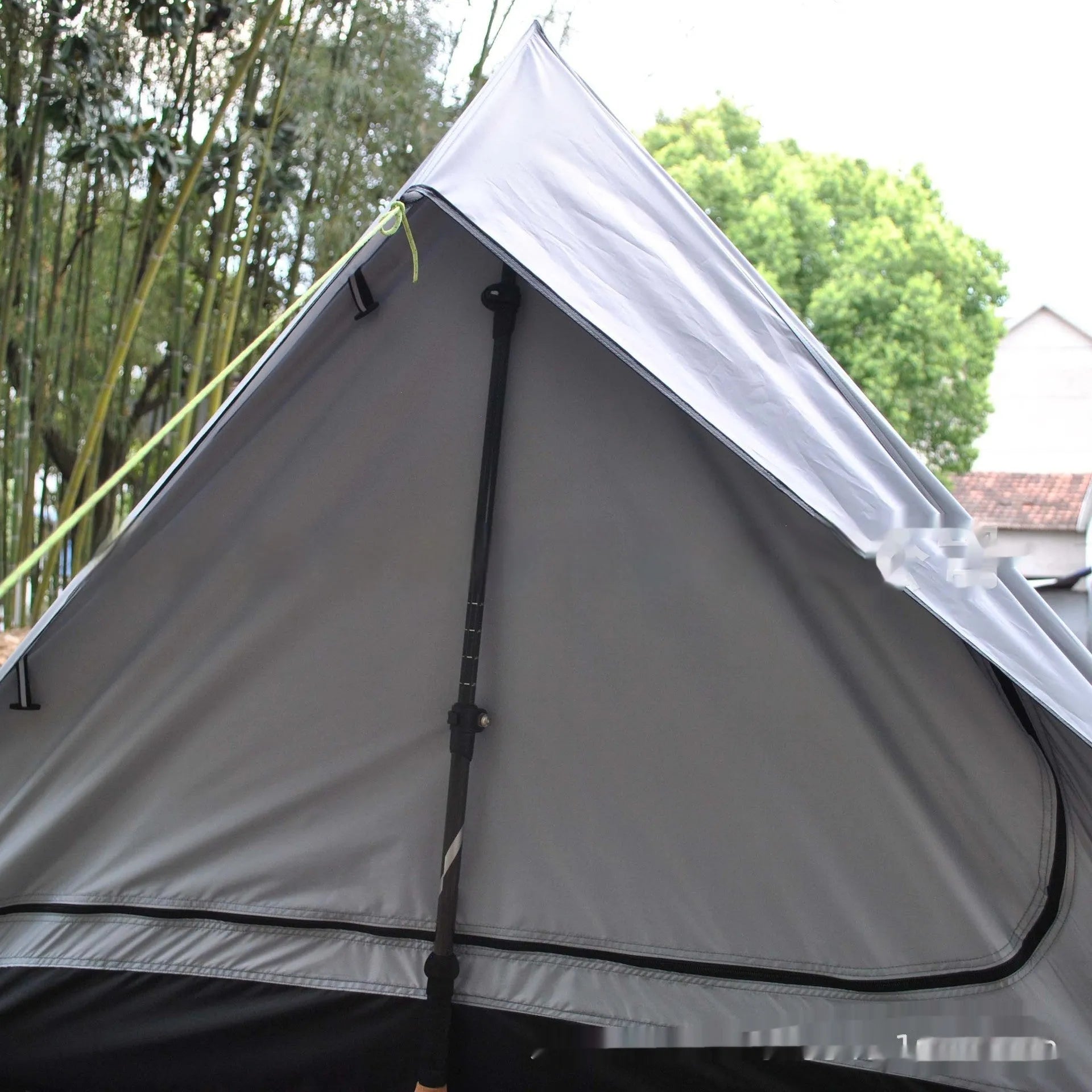 Brown A-line pole-free cabin tent pitched with hiking canes showing spacious interior dimensions