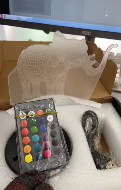 3D LED elephant touch lamp showing seven colour modes on a wooden desk