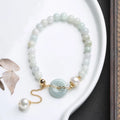 Natural emerald jade pearl bracelet with peace symbol buckle showing geometric charm arrangement