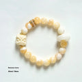 Hand-woven bracelet with large round grey agate and mellite beads on wrist.