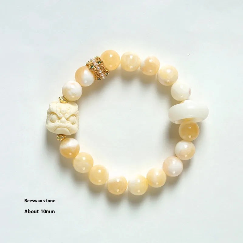 Hand-woven bracelet with large round grey agate and mellite beads on wrist.