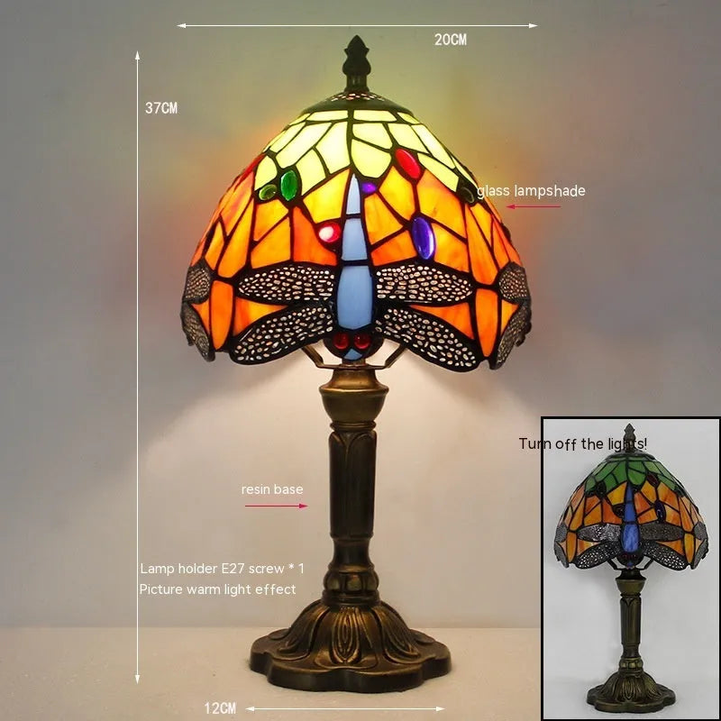 Stone Tiffany dragonfly table lamp in European retro style on a wooden table.