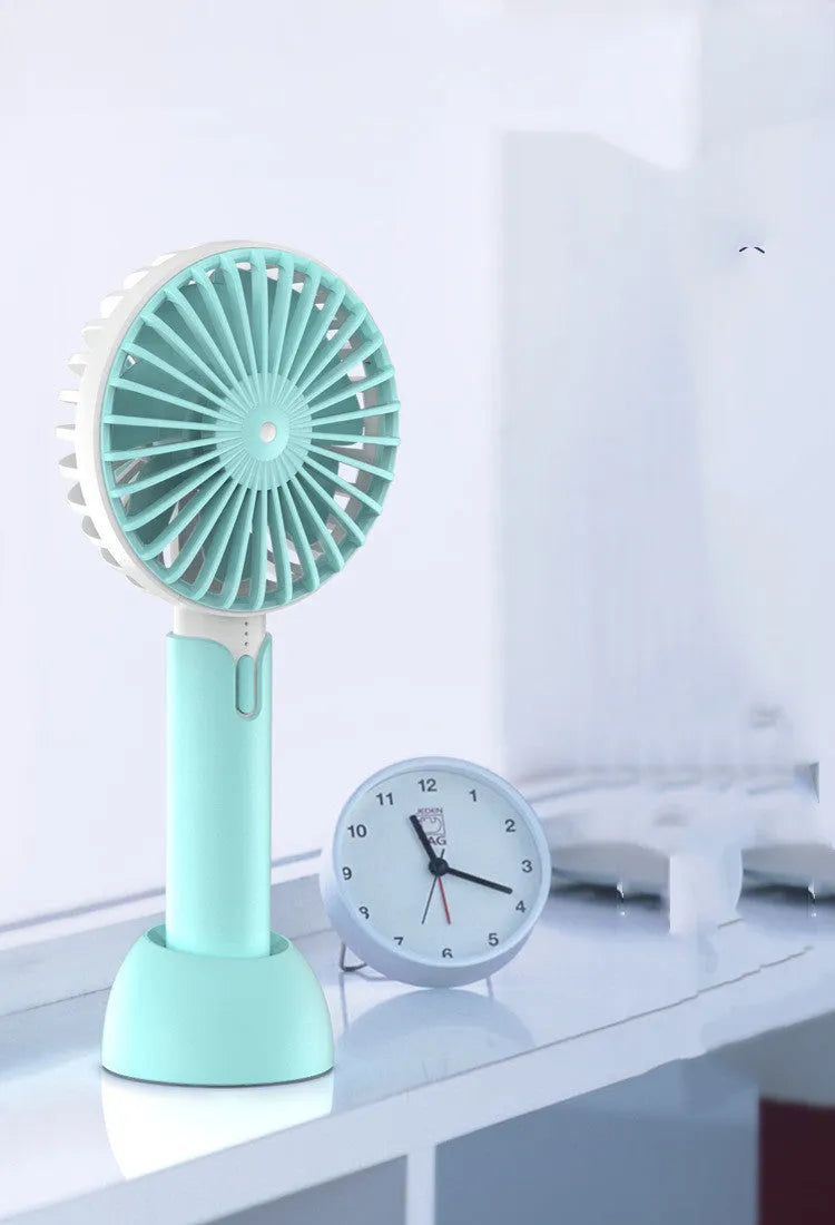 Blue mini handheld USB electric fan with three-speed control on desktop