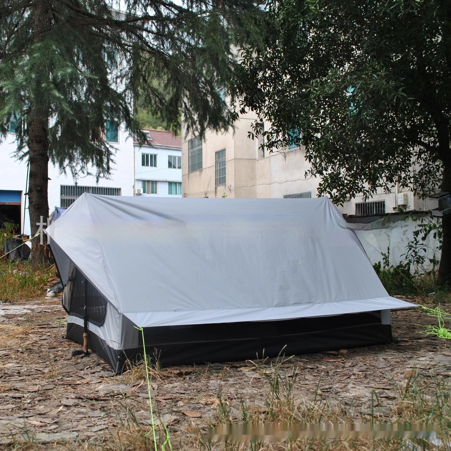 Brown A-line pole-free cabin tent pitched with hiking canes showing spacious interior dimensions