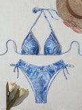 Denim blue printed women's bikini set with strap design, shown on a model.