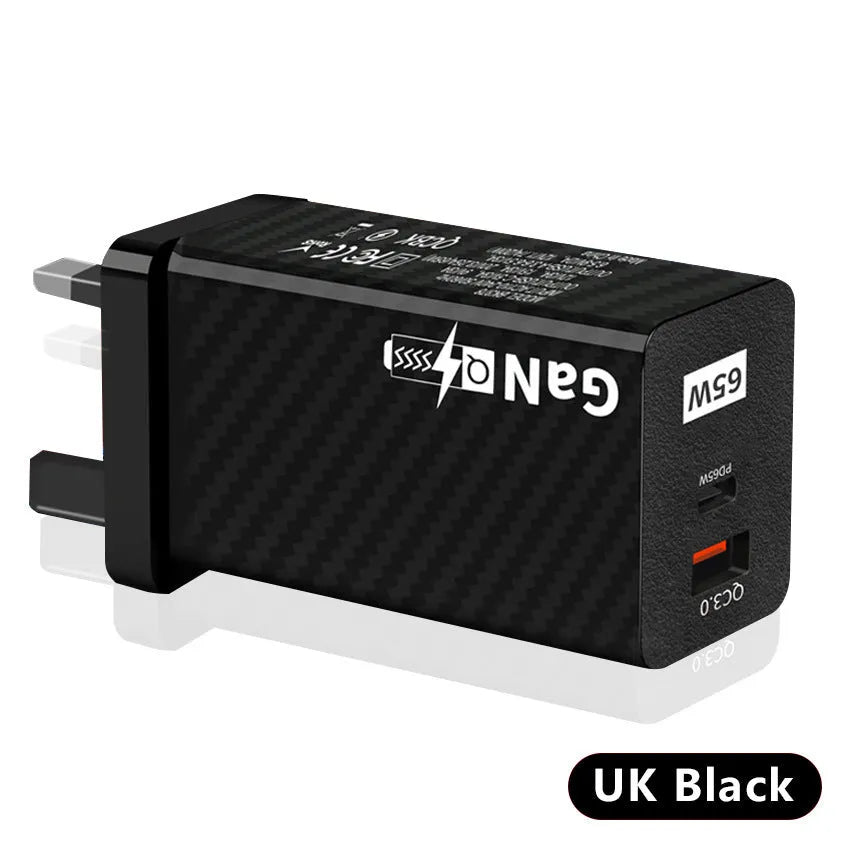 Compact black 65W GaN USB-C laptop charger with interchangeable EU UK US plug heads shown alongside scale